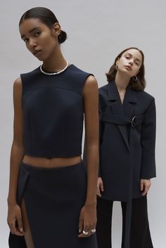 two models in black outfits standing next to each other