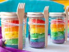 there are rainbows in the jars on the table with forks and spoons next to them