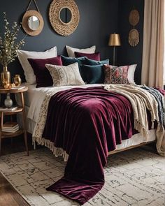 a bedroom with dark blue walls, white bedding and purple throw blankets on the bed