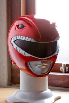 a red helmet is sitting on top of a white stand