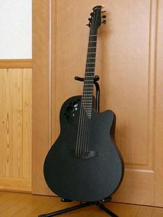 an acoustic guitar sitting on top of a stand