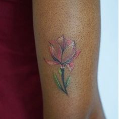 a woman's leg with a flower tattoo on the lower half of her thigh