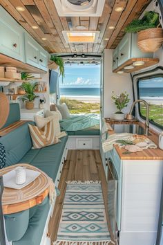 the interior of a camper with wood flooring and blue couches in it