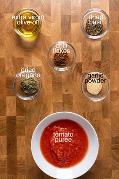 the ingredients to make tomato sauce are shown in bowls on top of a wooden table