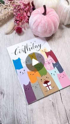 a birthday card with cats on it next to pumpkins and flowers in the background