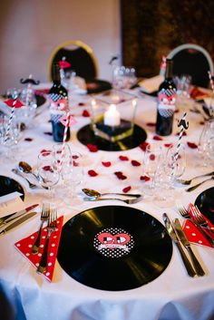 the table is set with black and white plates, silverware, and red napkins