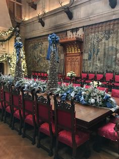 a long table with blue and white flowers on it in front of an ornately decorated wall