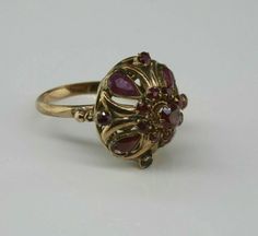 Antique 14K Yellow Gold Ruby Dome Ring, almost rose color gold, .5 inch high, .75 inch across, 4 pear shaped rubies, 12 round rubies, not calibre cut, 3.82 grams, Circa 1940, Size 7. SKU # BB264R25 Most rings are sizable for a small fee. If the ring you are considering is the incorrect size contact us for a quote. This listing contains photographs of the actual item you will receive. Our items are in excellent condition with little or no signs of wear and many are one of a kind pre-owned estate Victorian Rings Vintage, Antique Ruby Ring, Estate Jewelry Rings, Antique Jewelry Rings, Jewellery Ring, Dome Ring, Victorian Rings, Rings Vintage, Funky Jewelry