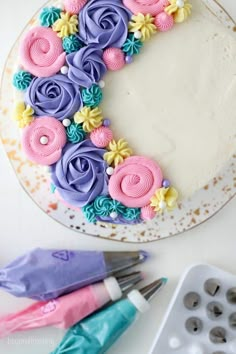 a decorated cake sitting on top of a white plate next to cupcake tins