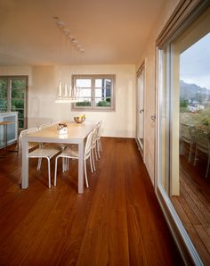 a dining room table and chairs with wooden floors in front of a sliding glass door