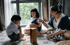 three children are sitting on the floor playing with each other