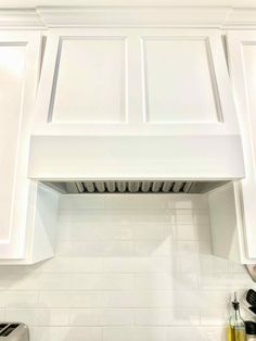 a stove top oven sitting inside of a kitchen next to white cabinets and counter tops