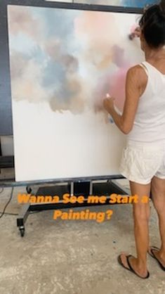 a woman in white shirt painting on wall with black and white background text says wanna see me start's painting?