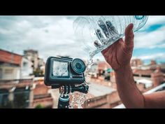 a person is holding up a water bottle and taking a photo with a camera on top of a building