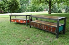 two benches sitting in the grass near each other with letters on them that spell out ford