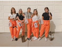 five people dressed in orange pants and white t - shirts, posing for a photo