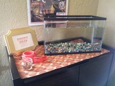 a fish tank sitting on top of a table next to a framed photo and other items