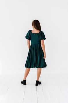 Features Square neckline Short balloon sleeves with elastic Back zipper closure Fit and flare style with bubble skirt Green-teal color 100% Polyester Size + Fit XS 0, Small 2-4, Medium 4-6, Large 8-10, X-Large 12-14, 2X 16-18, 3X 20-22, 4X 24-26 Kristin is 5'4", a size 1, and is wearing a XS Ashley is 5'6", a size 18, and is wearing a size 2X Runs one size small. Size chart is adjusted accordingly. We recommend sizing up from your standard size, especially if in between sizes. The bust does not Short Balloon Sleeves, Curvy Swim, Chanel Dress, Bubble Skirt, Curvy Dress, Teal Color, Green Skirt, Swim Bottoms, Teal Colors