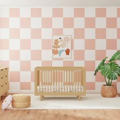 a baby's room with pink and white checkered wallpaper, a crib, potted plant, and dresser