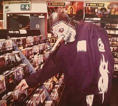 a person in a store with some kind of mask on their face and hands behind his head