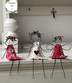 three little angel figurines sitting on top of a window sill