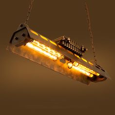 a light fixture hanging from the ceiling with lights on it's sides and an image of a boat in the background