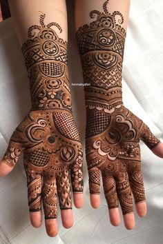 two hands with henna designs on them