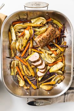 a pan filled with meat and vegetables on top of a table