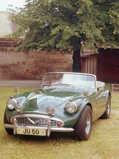 an old car is parked in the grass