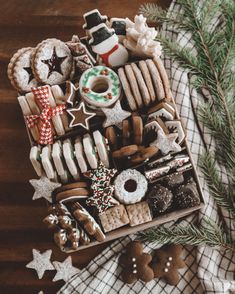 a wooden table topped with lots of different types of cookies