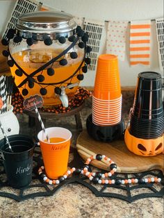 an assortment of halloween party supplies including cups, plates and candy bar decorations on a table