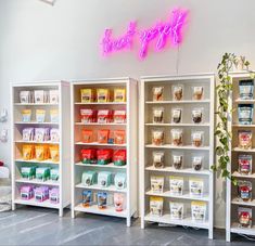 a store with shelves filled with different types of food and drinks on display next to a neon sign that says treat yourself