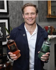 a man holding two bottles of alcohol in his hands