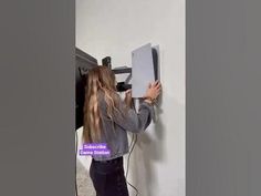 a woman is using a wall mounted device