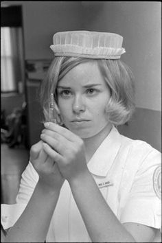 a black and white photo of a woman with a hat on her head