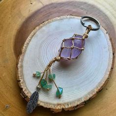 a piece of wood with a wire wrapped around it and a glass bead hanging from the end