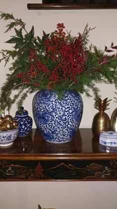 a blue and white vase sitting on top of a wooden table next to other items