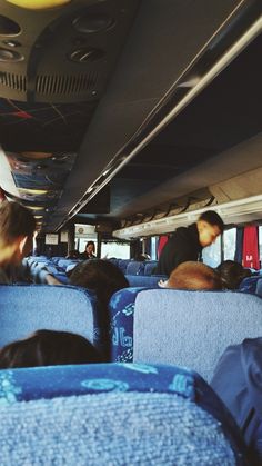 people are sitting in the back of a bus with their backs to the camera man