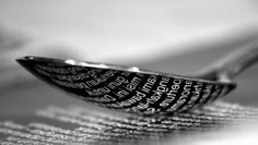 black and white photograph of a spoon with words on it