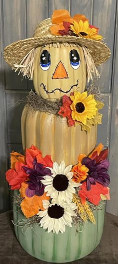 a pumpkin decorated like a scarecrow with sunflowers