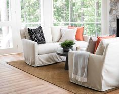 a living room filled with furniture and a fire place in front of a large window