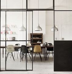 an empty room with chairs and tables in the center is seen through large glass windows