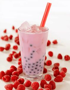 raspberry milkshake with ice and strawberries scattered around