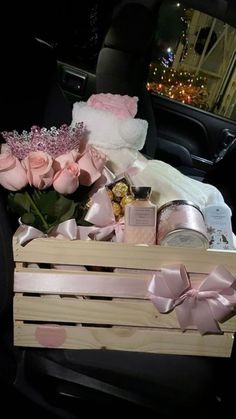 a wooden crate filled with lots of pink roses and other items in the back of a car