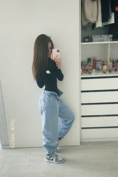 a woman taking a selfie with her cell phone while standing in front of a closet