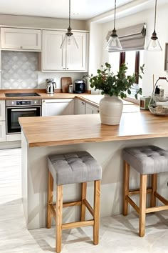 a kitchen with two stools and a center island