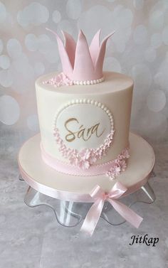 a pink and white cake with a crown on top