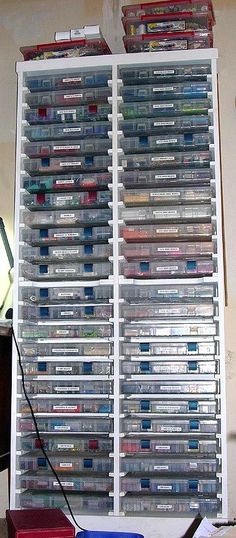 there are many video game cases stacked on top of each other in front of a wall