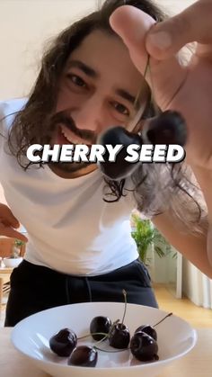 a man holding a plate with cherries on it and the caption cherry seed