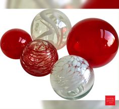 three red and one white glass balls on a white background